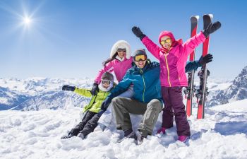 Happy family skiing during winter holidays.